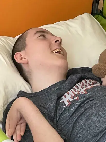 Jack smiling in hospital bed with his teddy bear