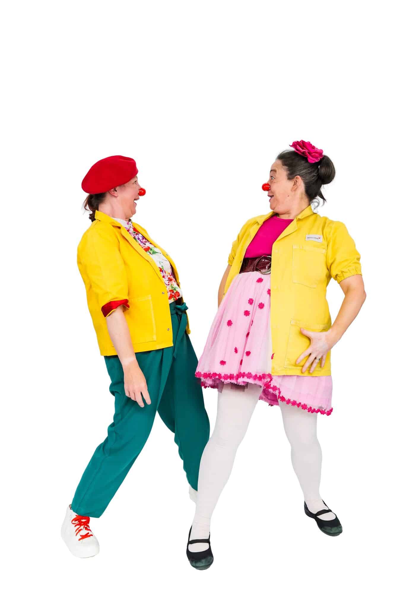 Two female Clowndoctors laughing together in yellow coats and red noses